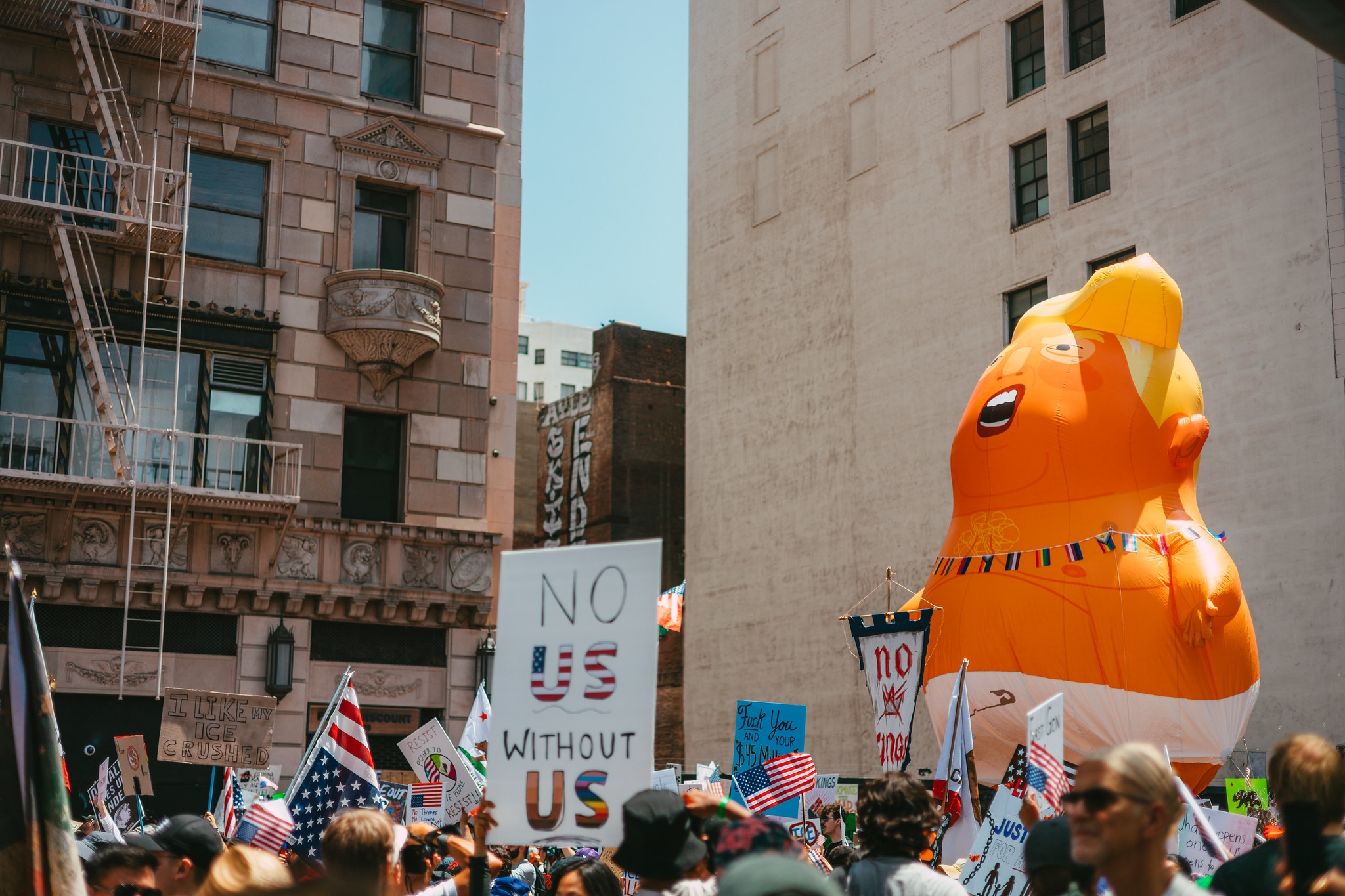 Protesters march in Downtown Los Angeles for the "No Kings" protest on June 14, 2025. A sign reads "No U.S. without us."