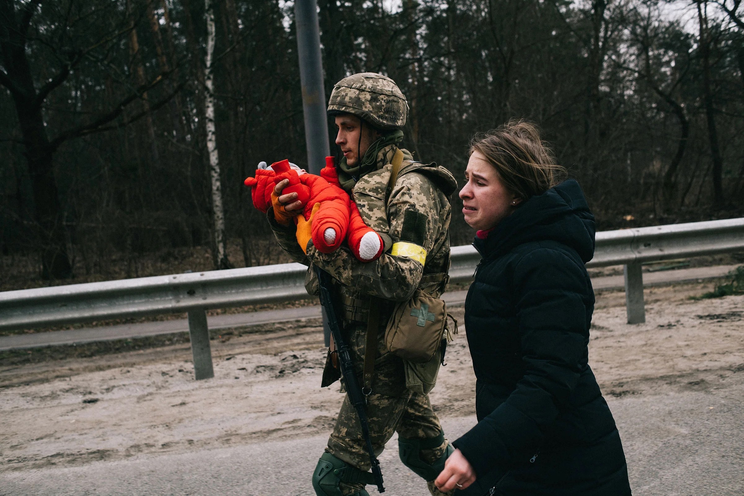 A Ukrainian soldier helps Julia Pavliuk and her daughter Emma evacuate the Kyiv suburb of Irpin, Ukraine, which Russian forces have tried to seize as part of their push to encircle the capital on March 5.
