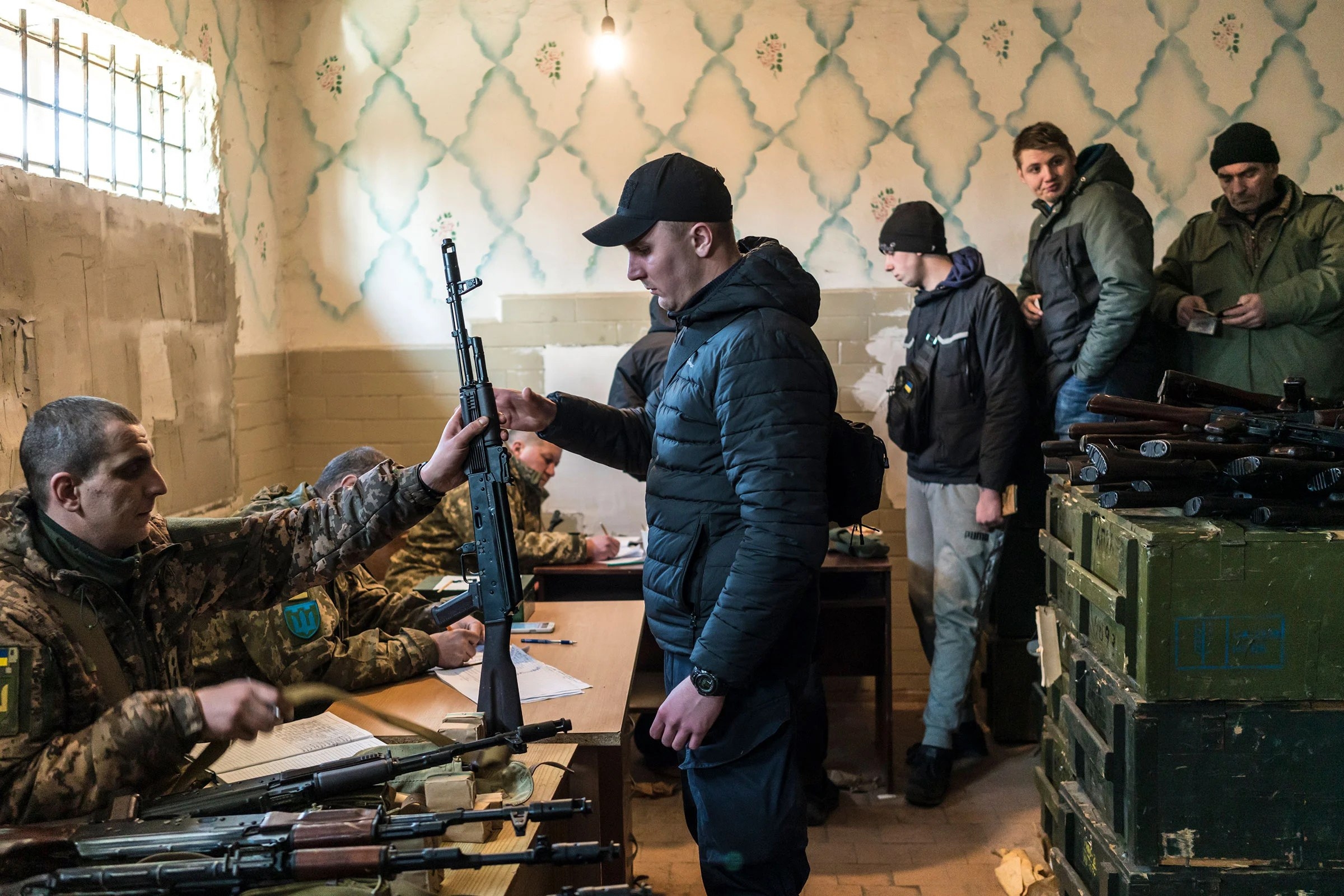 Civilian volunteers receive weapons, in a nationwide campaign to recruit, register and draft men for the war against Russia, in Fastiv, Ukraine, on Feb. 25.
