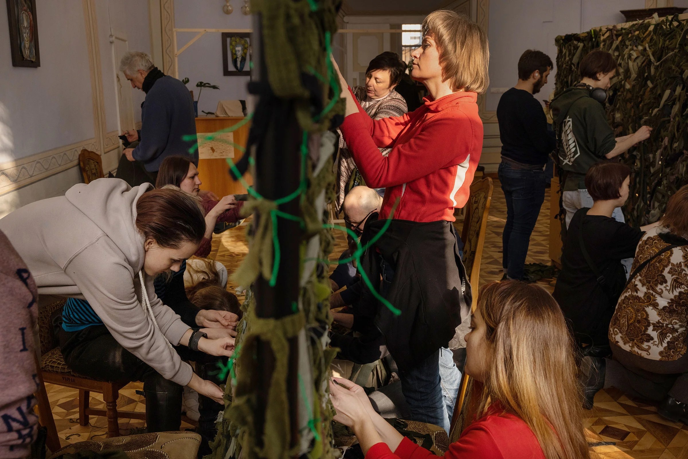 Volunteers at a library in central Lviv, Ukraine, weave camouflage nets to send to the soldiers on the front lines on March 7.