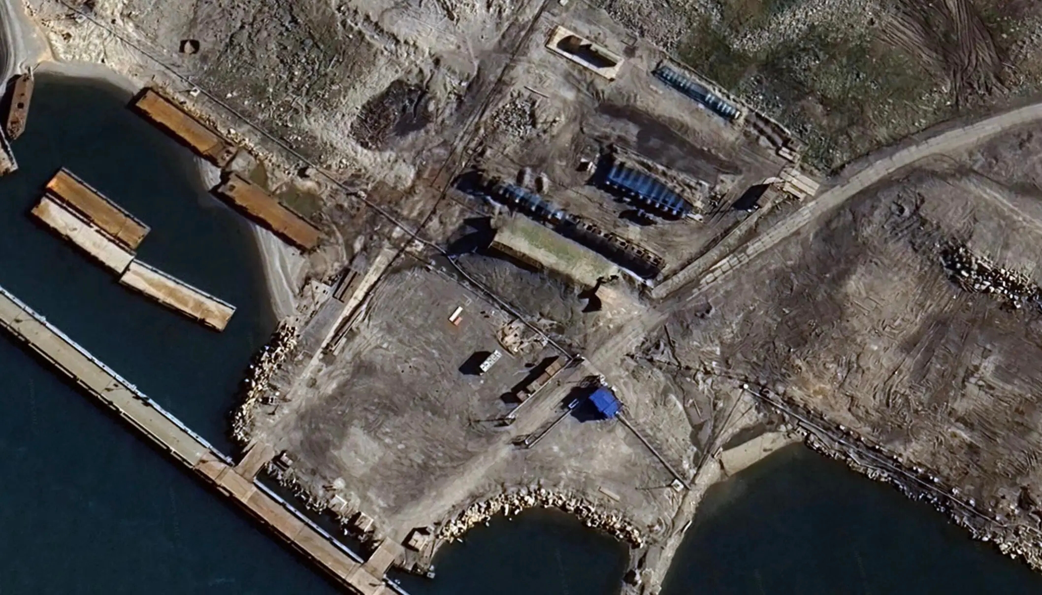 Blue-tinted metal nets, known as “cope cages,” cover three rows of fuel storage tanks near the Russian port facility in Severny on the Novaya Zemlya archipelago. Source: Google Earth / The Barents Observer
