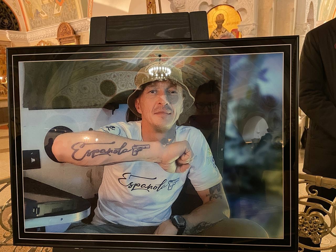 A photo of Stanislav Orlov diplayed at his funeral service, depicting him showing off his tattoo of Espanola's logo on his forearm. Photo: The Insider