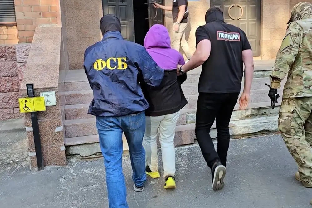 Russian security officers leading a detained suspect into a building. Photo: FSB