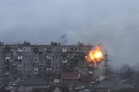 An explosion erupts from an apartment building on Mytropolytska Street, Mariupol, Ukraine, after fire from a Russian army tank.