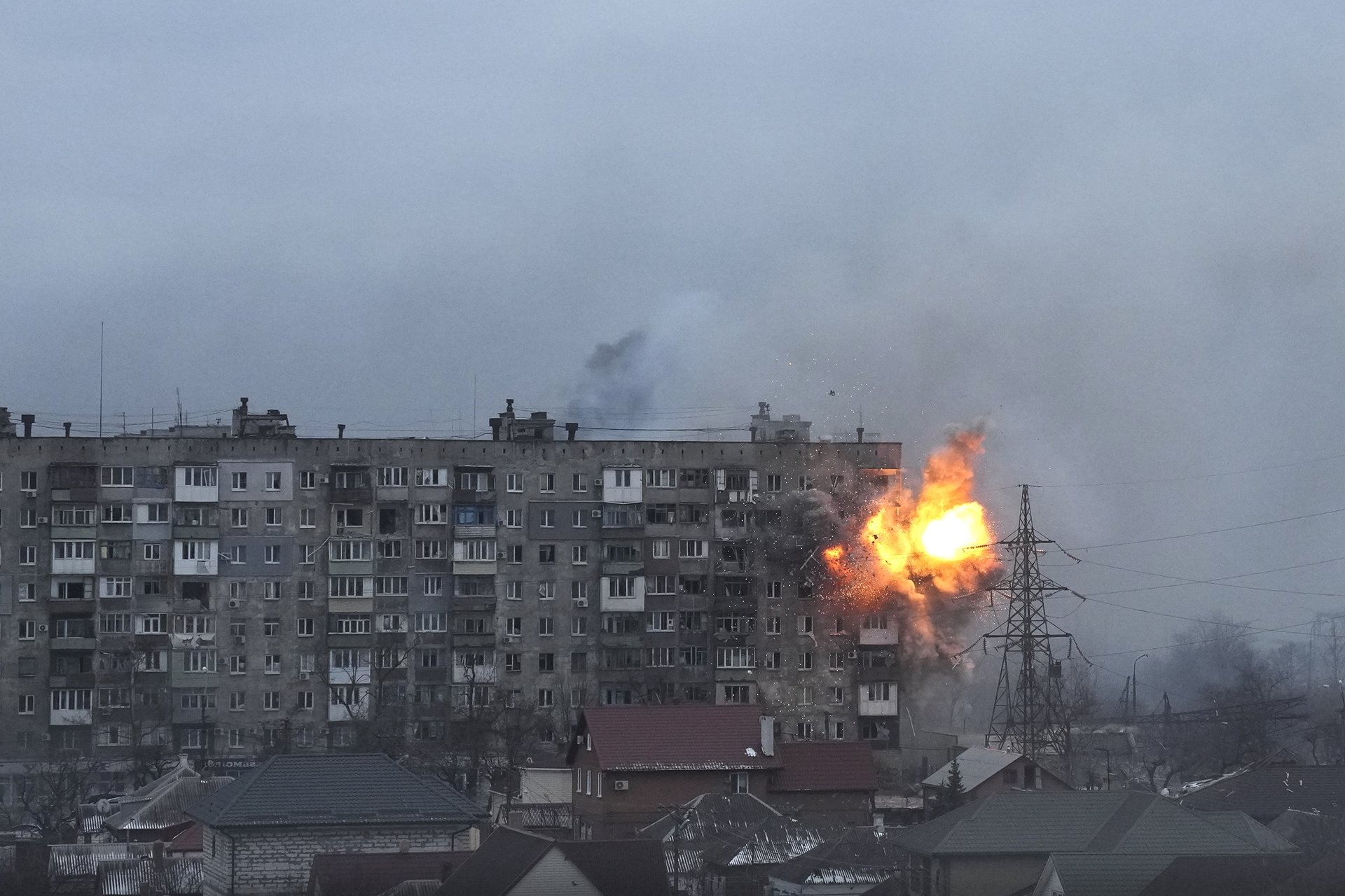 An explosion erupts from an apartment building on Mytropolytska Street, Mariupol, Ukraine, after fire from a Russian army tank.