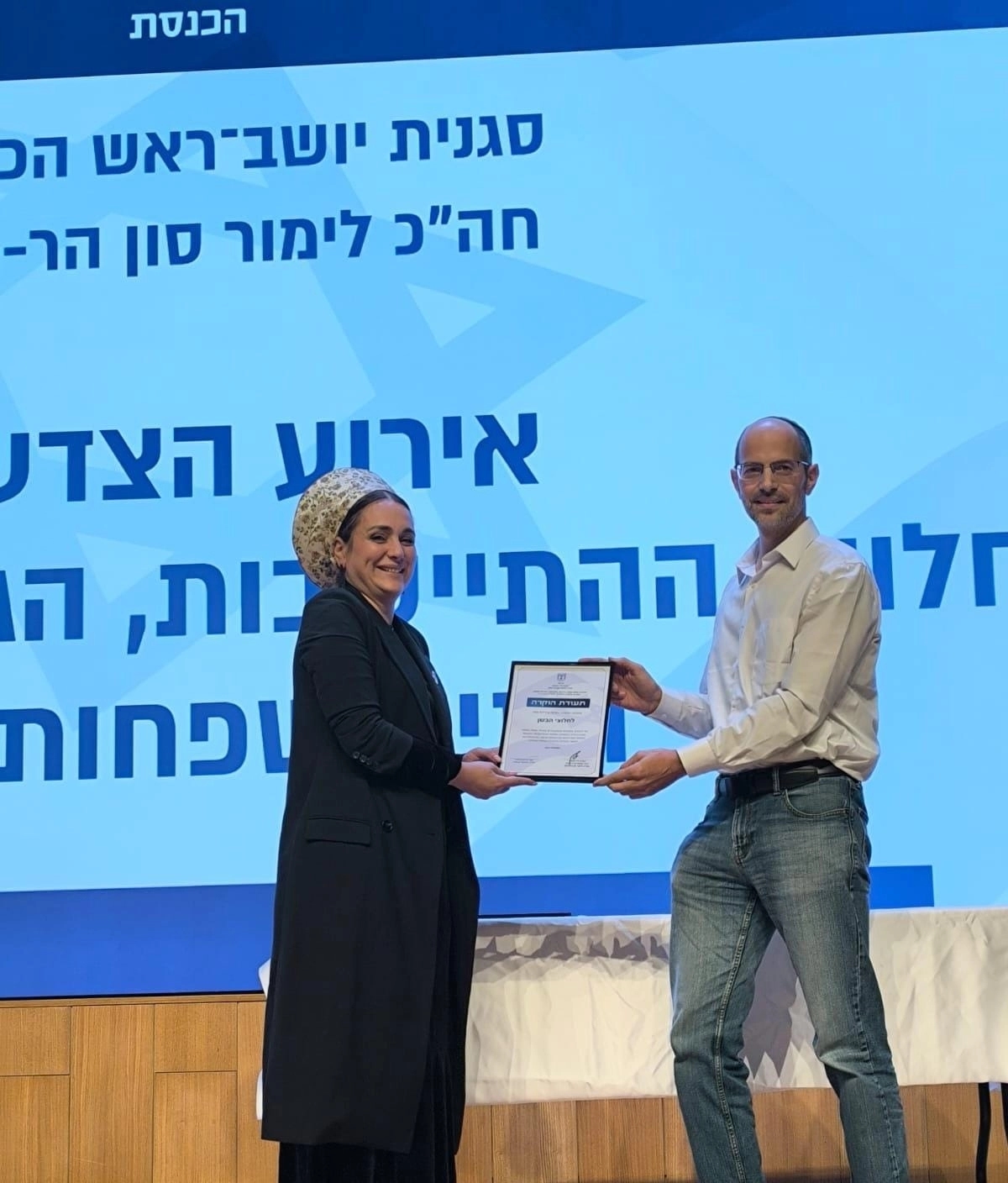 Knesset member Limor Son Har-Melech presents an award to Pioneers of the Bashan leader Amos Azari. January 2026 qhxidiqxkiqekinv
