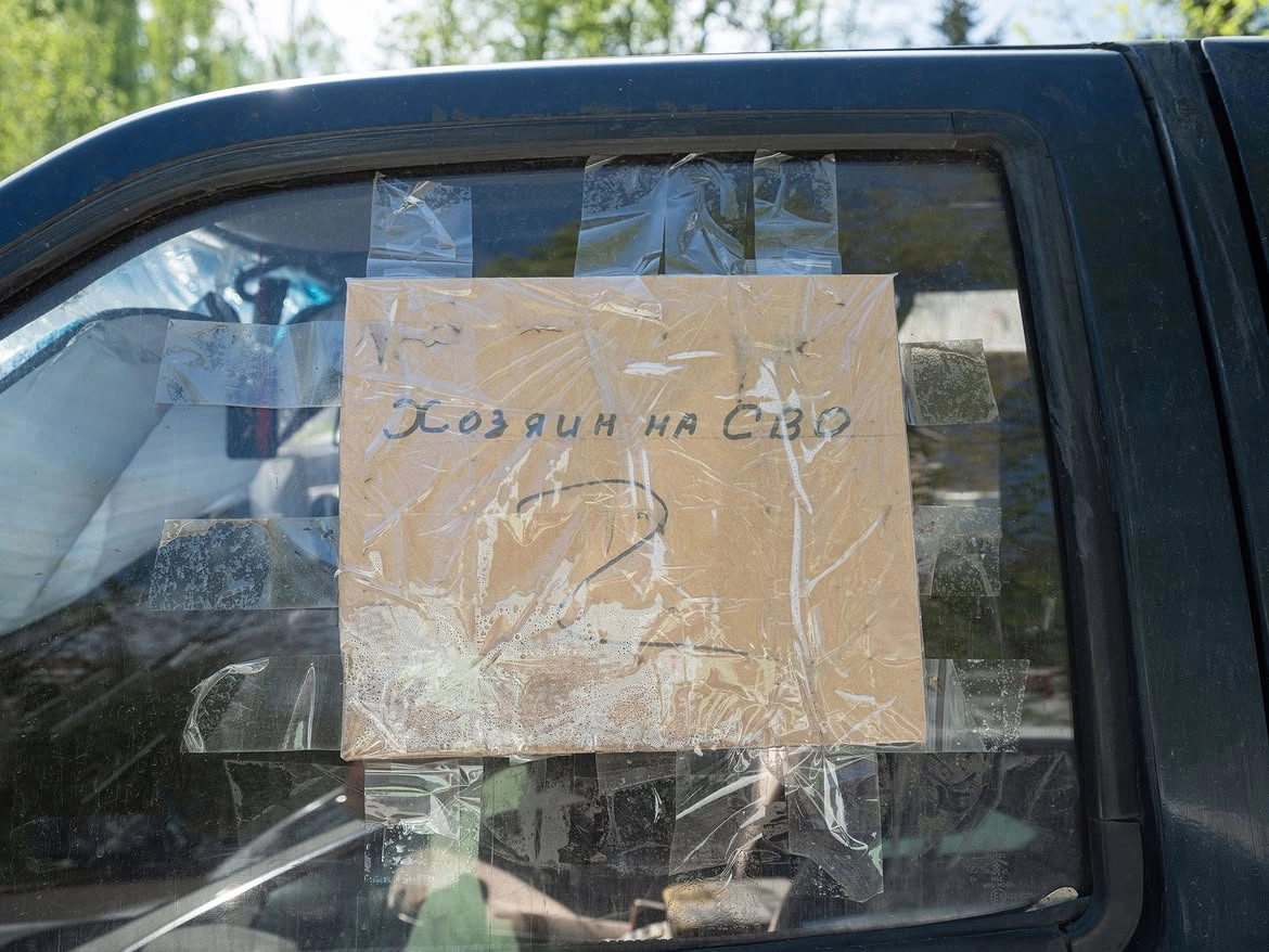 A sign tucked under the side window of a car in Moscow, May 2026