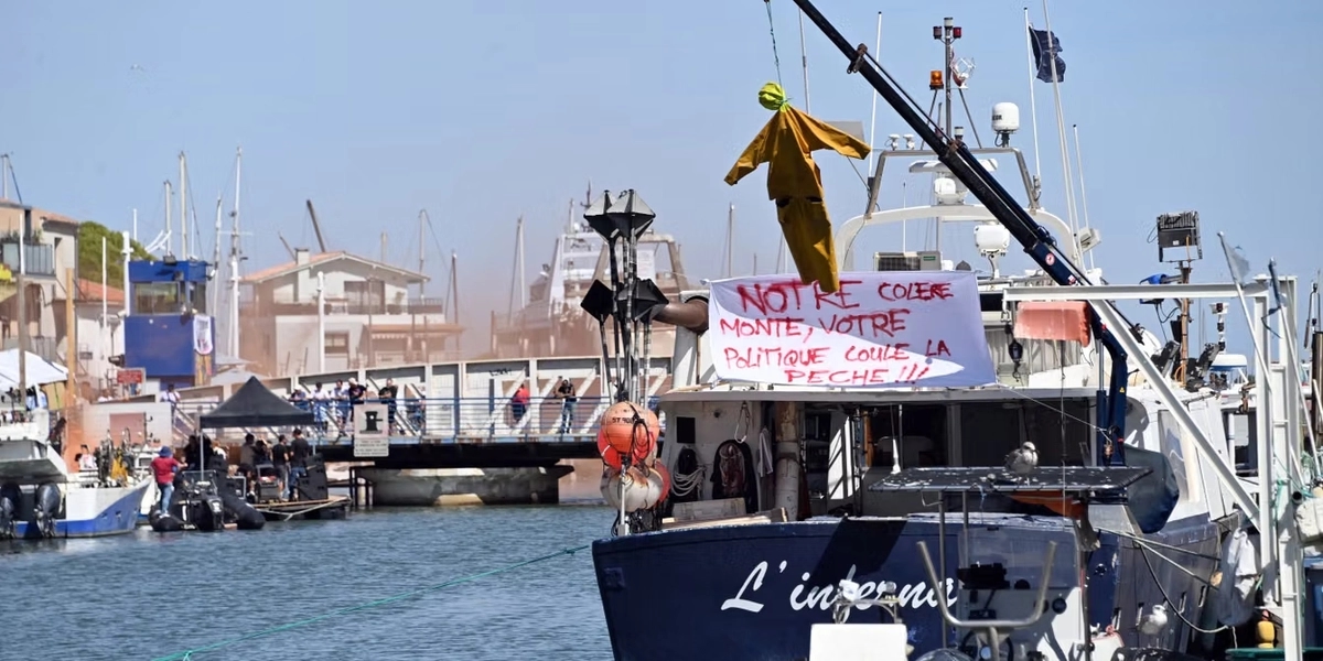 “Our outrage is growing, while your policies are destroying the fishing industry,” reads the sign.
