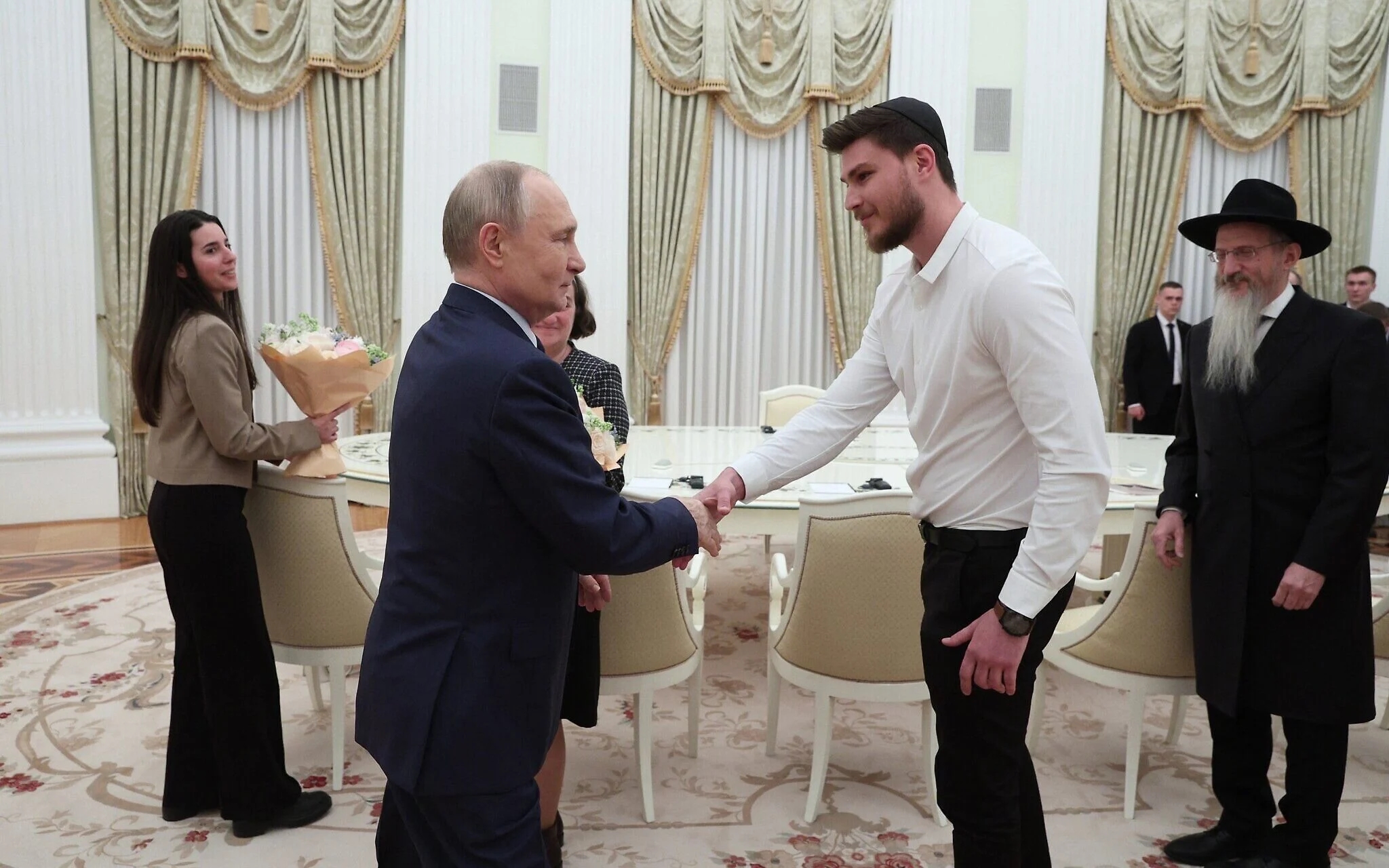In this pool photo released by Russia’s state agency Sputnik, Vladimir Putin is seen shaking hands with Sasha Trufanov, a former hostage held by Palestinian Islamic Jihad, during a meeting at the Kremlin in Moscow on April 16, 2025. Photo: Sofia Sandurskaya / Pool / AFP