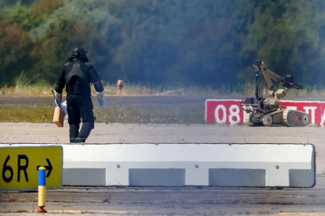 A police officer approaches a bomb disposal robot wearing a blast suit after the discovery of a drone at Leipzig/Halle Airport in August. Photo: Reuters / Axel Schmidt