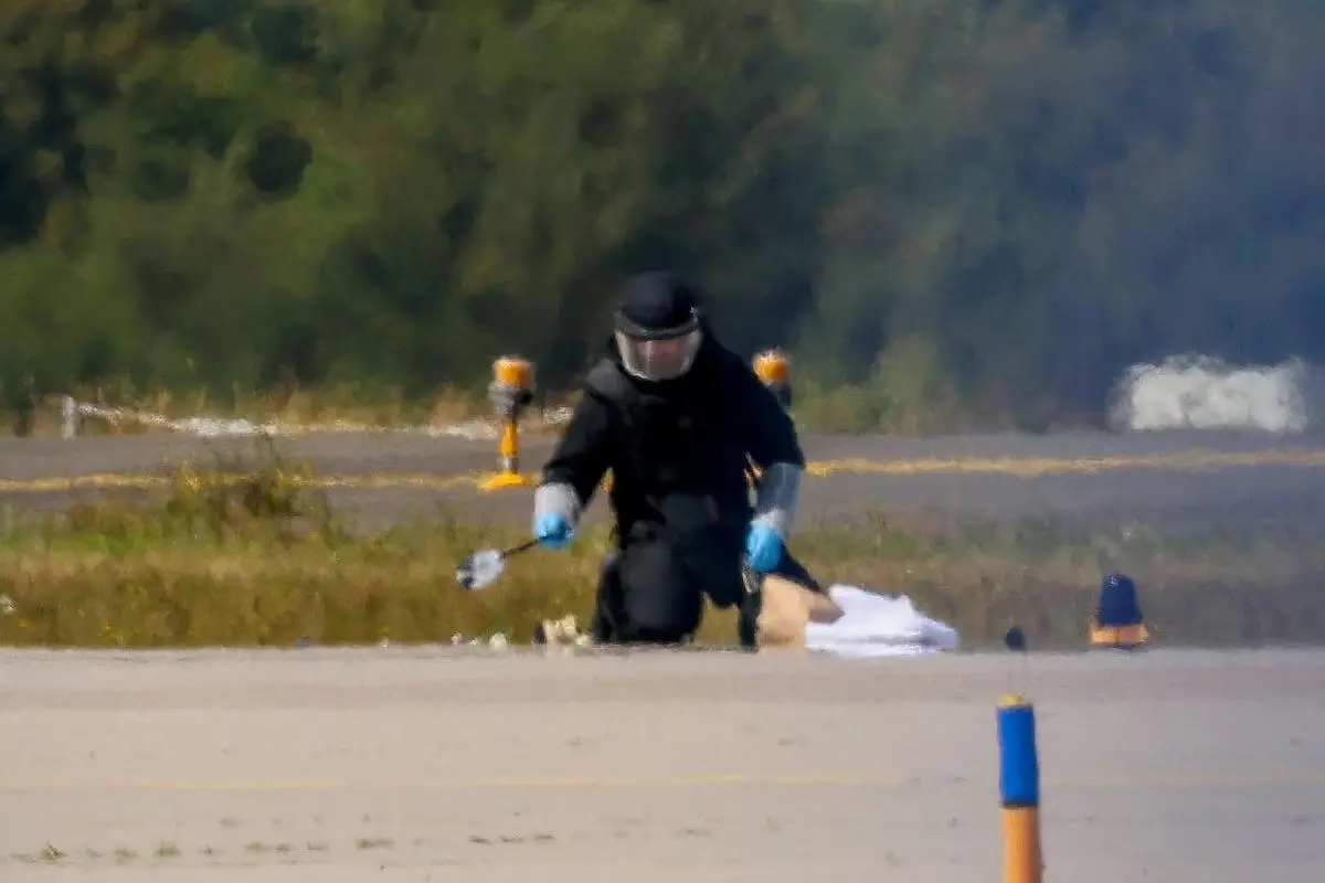 A police officer in protective gear at Leipzig/Halle Airport on Aug. 5, 2026, after a drone was found near a Ukrainian transport plane. Photo: Axel Schmidt / Reuters
