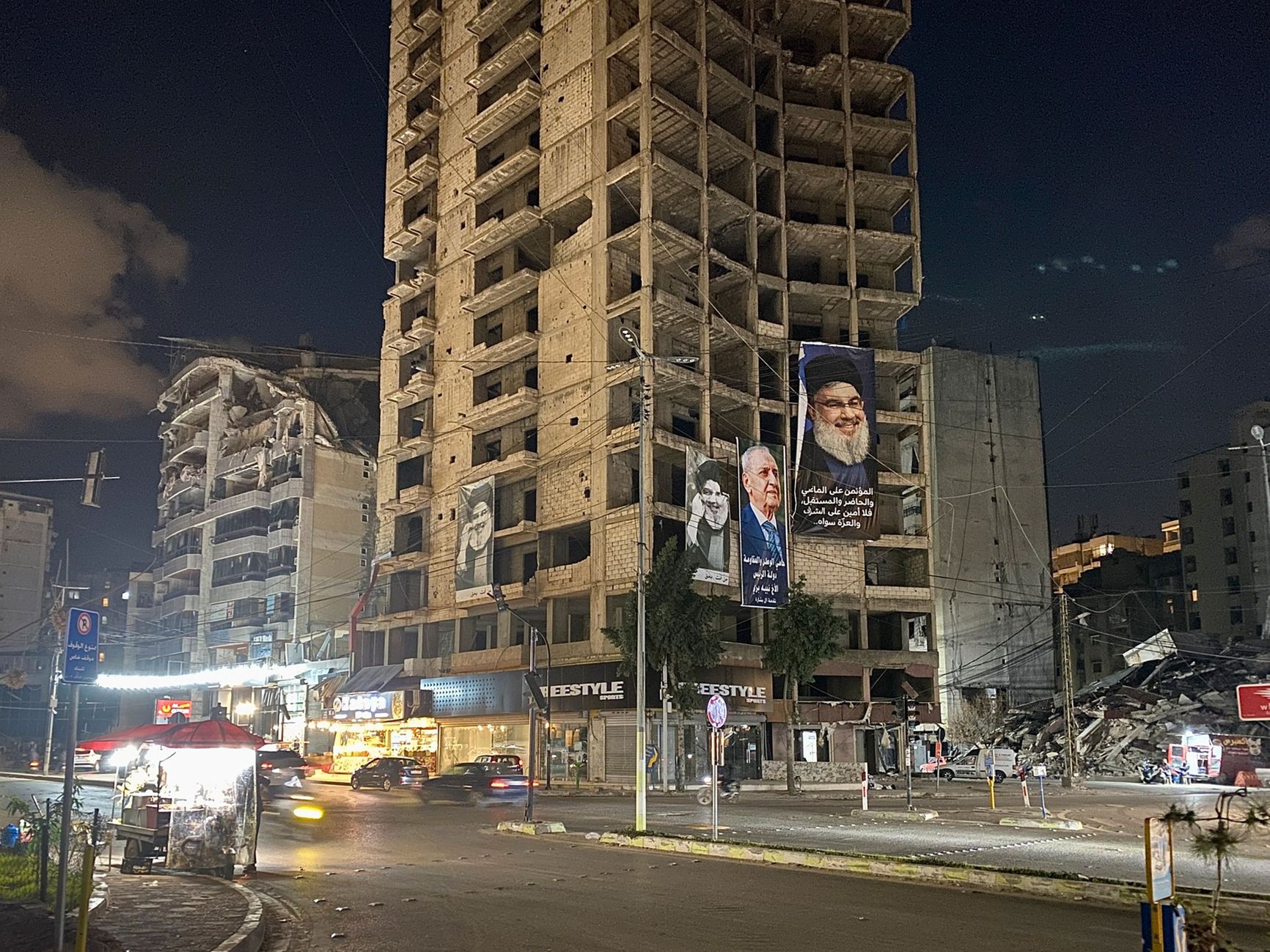 Destroyed buildings along Nasrallah Avenue, bearing portraits of Hezbollah leaders and the Shiite speaker of parliament