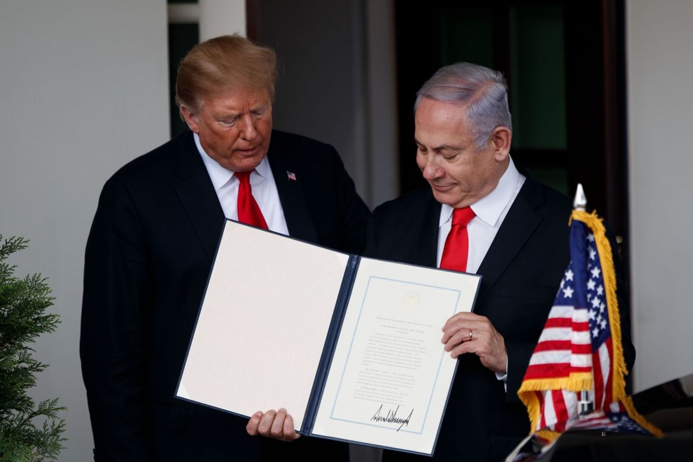 Donald Trump and Israeli Prime Minister Benjamin Netanyahu display the signed peace plan