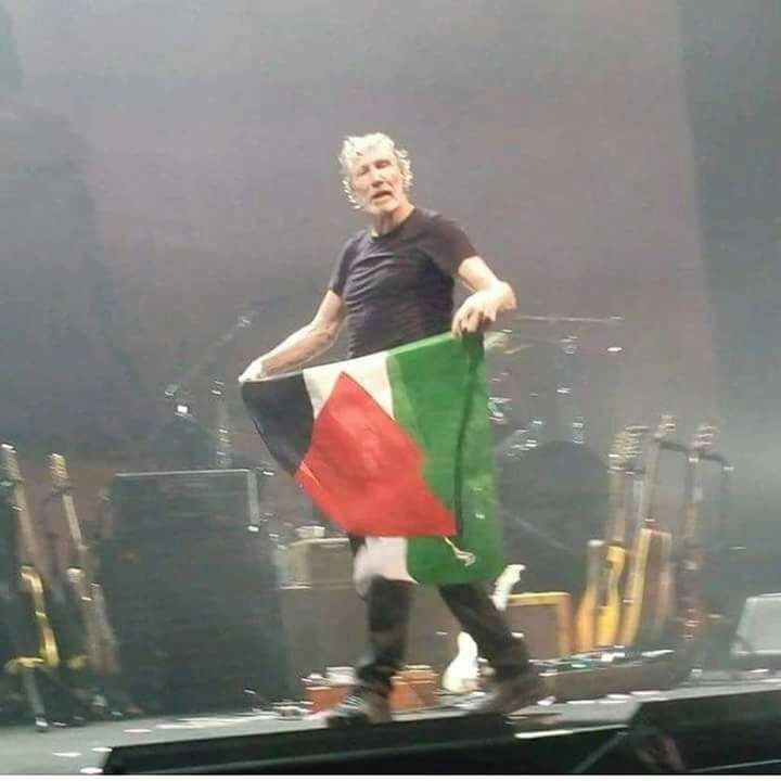 Pink Floyd co-founder Roger Waters carries the Palestinian flag onstage during a concert.