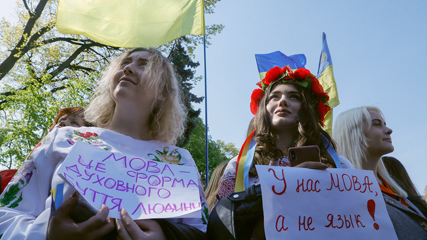Demonstrators in Kyiv hold posters in support of a 2019 law that mandated the use of the Ukrainian language in most aspects of public life. Left poster: "Language is a form of a person’s spiritual life." Right: "We have 'mova' [Ukrainian word for 'language'], not 'yazyk' [Russian word for 'language']!"