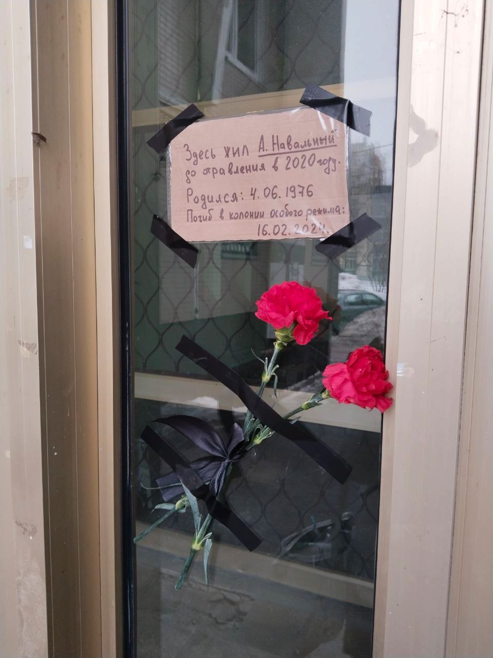 The note reads “A. Navalny lived here until he was poisoned in 2020. Born: June 4, 1976. Died in a special regime colony: February 16, 2024.”
